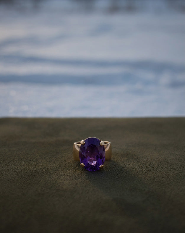 Large Oval Amethyst Solitaire Ring with 8mm Polished Band in 14k Yellow Gold — lifestyle photography