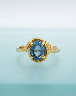Oval Blue Topaz Ring with Diamond Accent in 14k Yellow Gold Bypass Setting