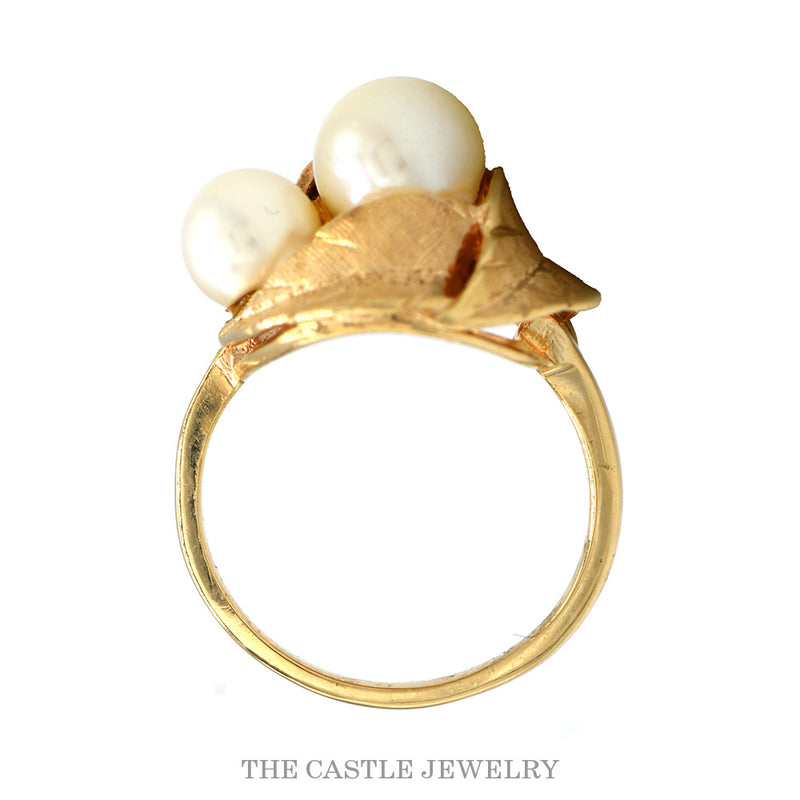 Front-facing view of the double pearl bypass ring with brushed gold leaves in 14k yellow gold