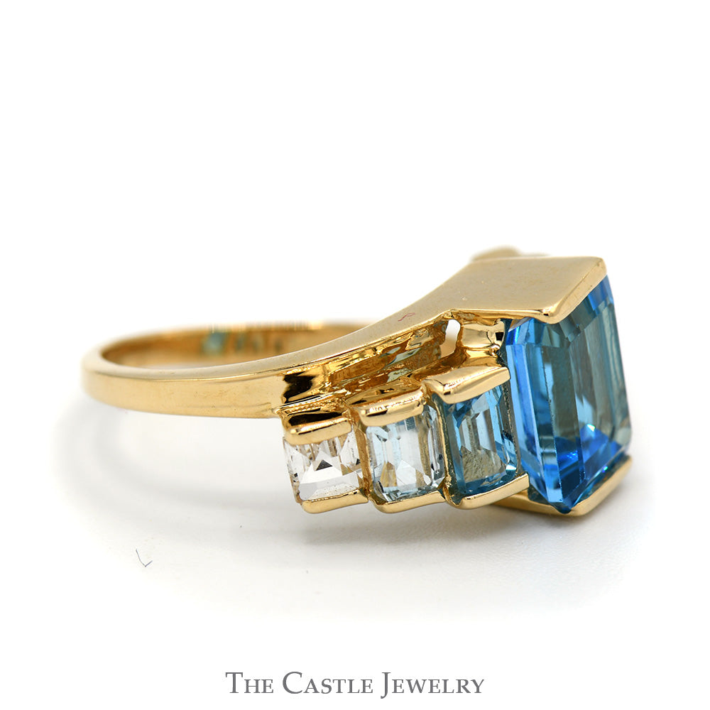 Emerald Cut Blue Topaz Ring with Graduated Design in 14k Yellow Gold Bypass Setting