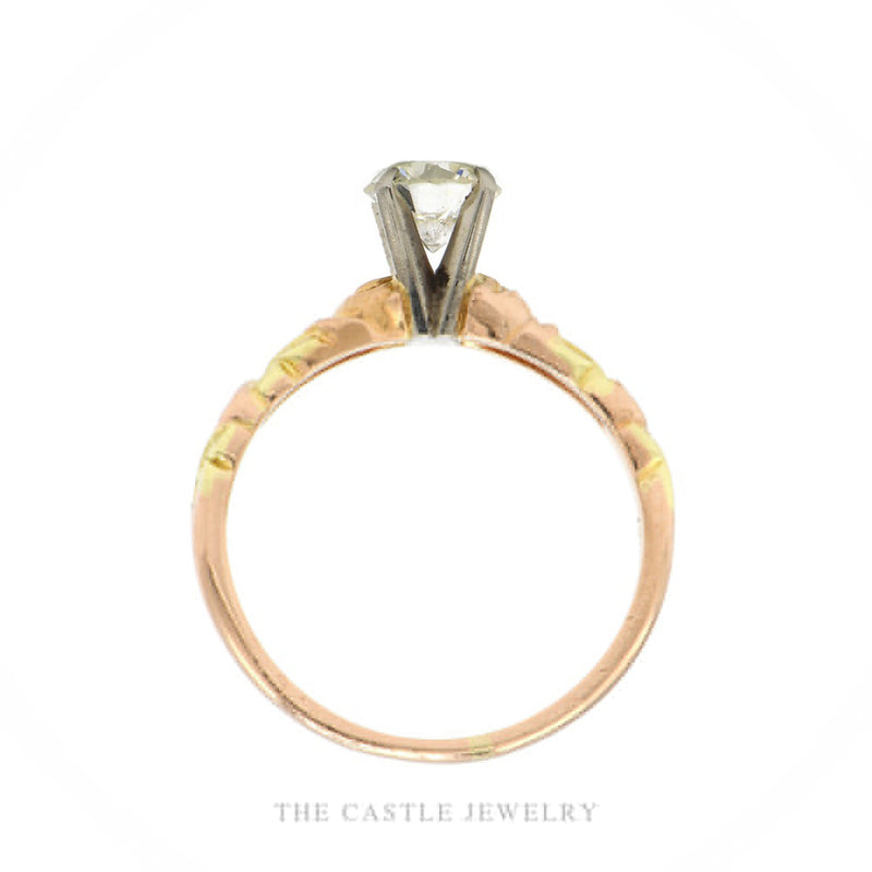 Front-facing view of the 14k tri-color gold diamond solitaire ring showing yellow, rose, and white gold leaf carving on the shank